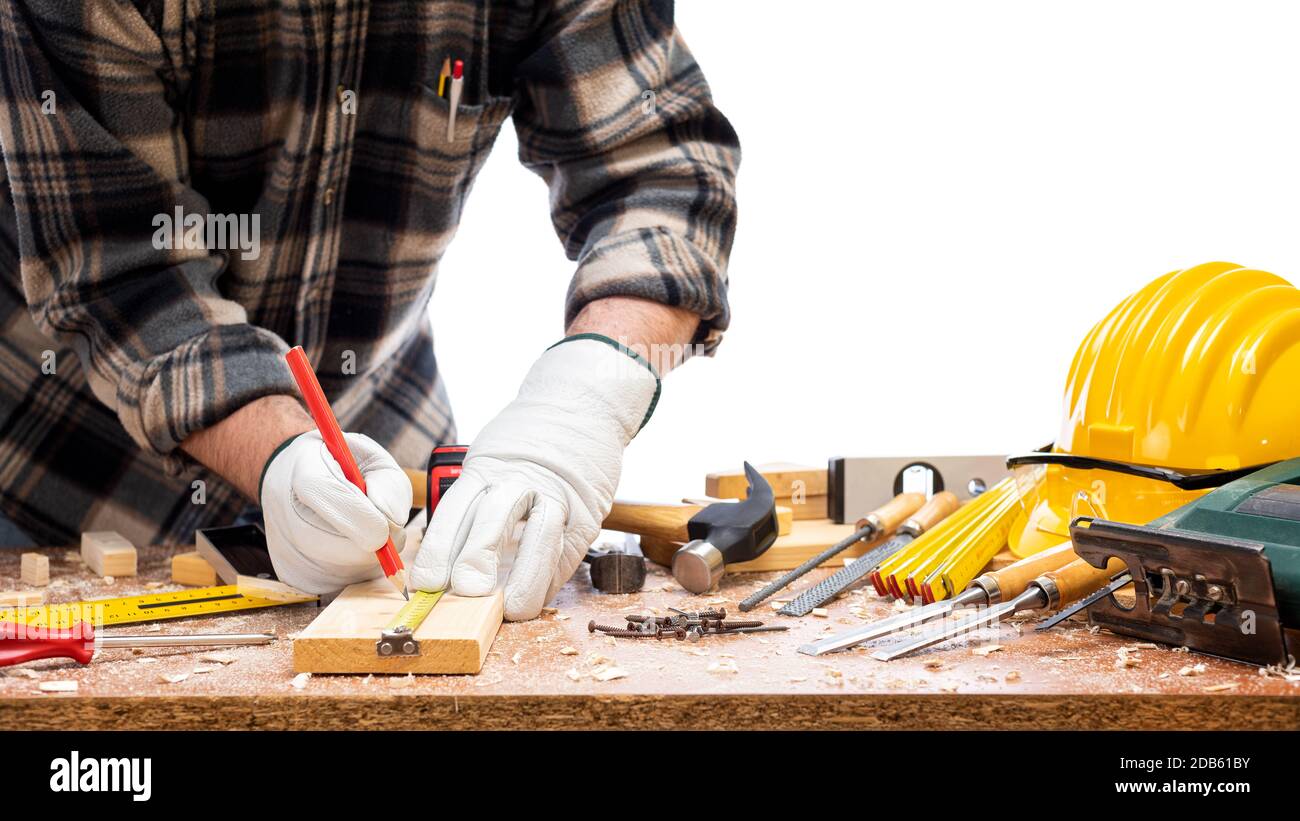 Nahaufnahme. Tischler mit den Händen durch Handschuhe mit Bleistift geschützt und das Messgerät markiert die Messung auf einem Holzbrett. Bauindustrie. Iso Stockfoto