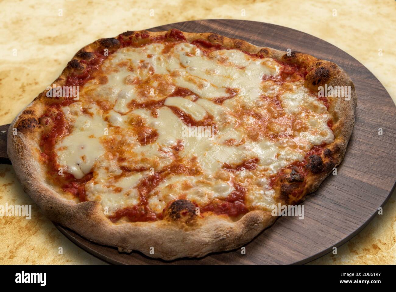 Pizza mit Tomatensouce und Mozzarella-Käse auf einem hölzernen Platine Stockfoto