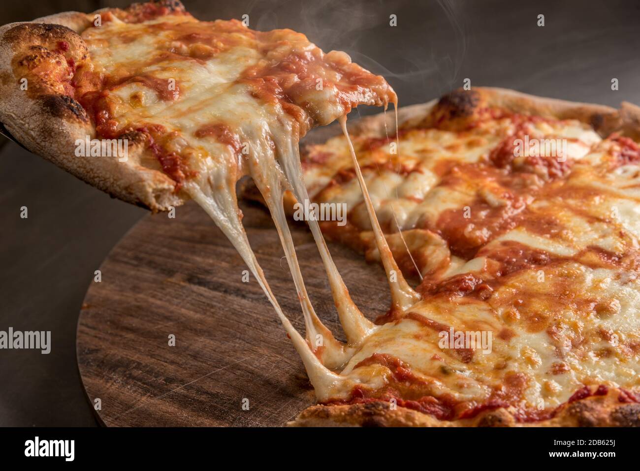 Scheibe Pizza mit Tomate und schmelzenden heißen Mozzarella, Nahaufnahme Stockfoto