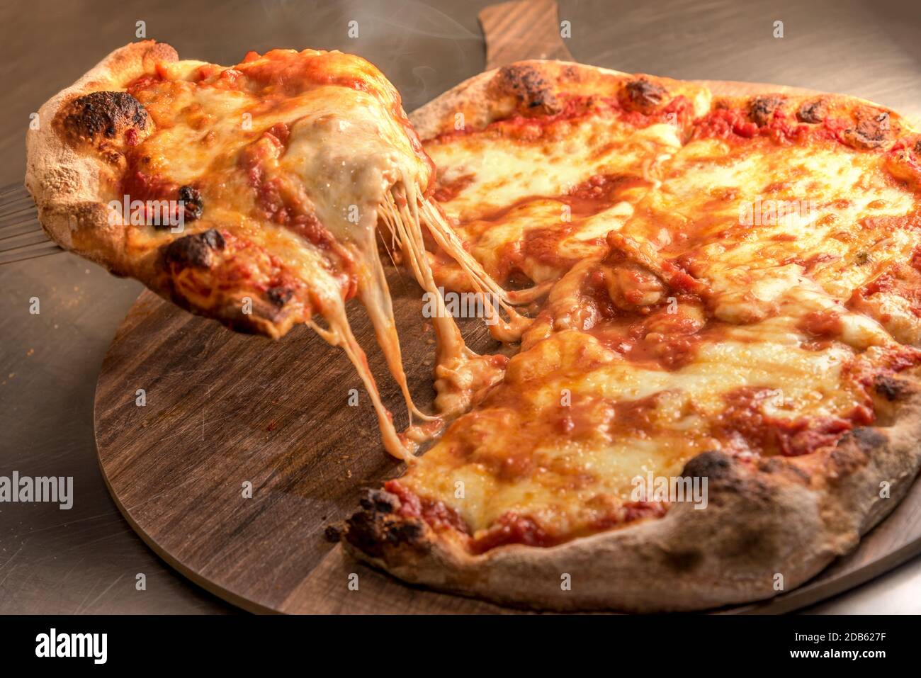 Scheibe Pizza mit Tomatensauce und mit heißem Käse Sich drehende Mozzarella Stockfoto