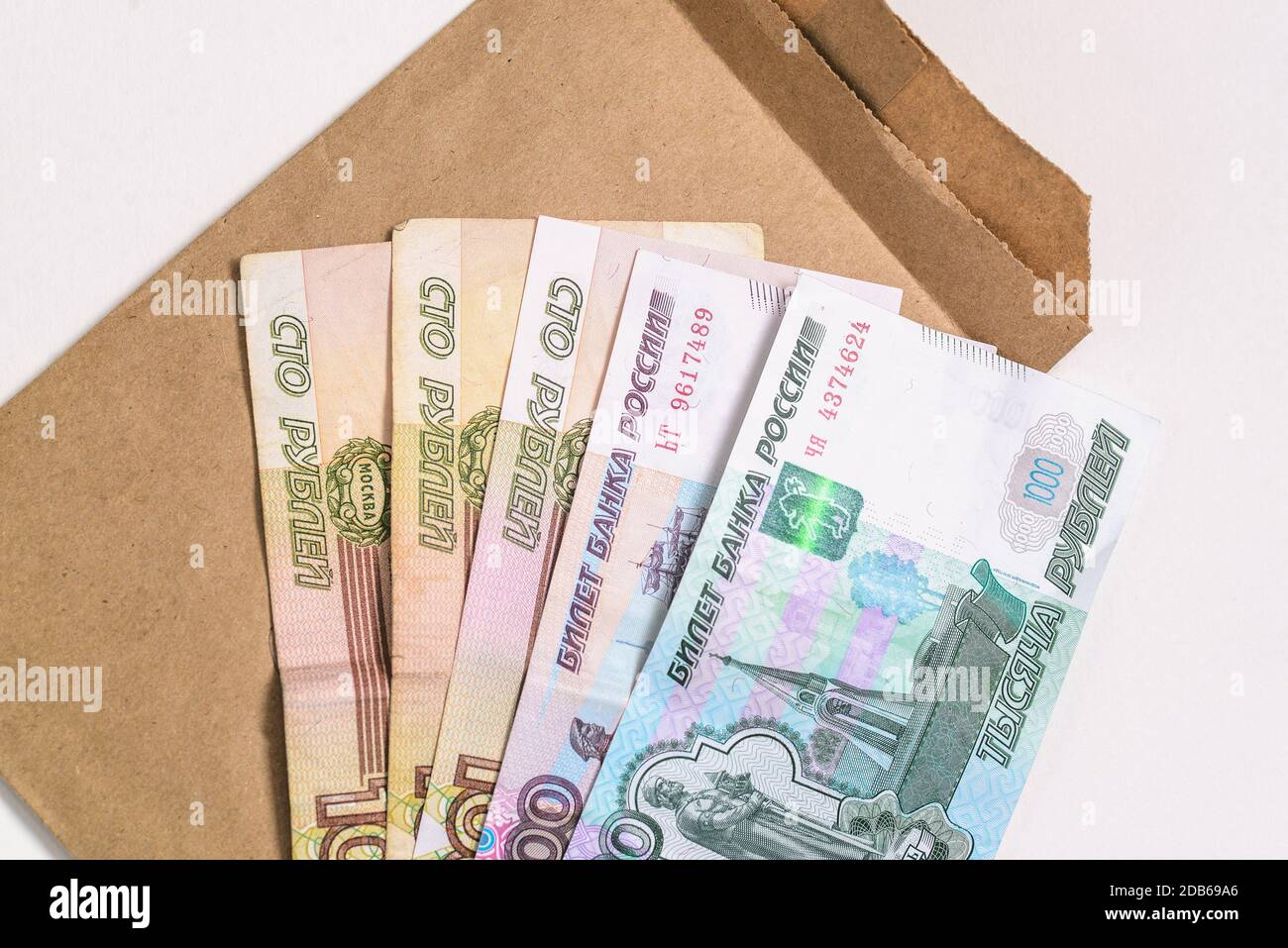 Russisches Geld und ein Pappumschlag. Banknoten isoliert auf weiß. Draufsicht, flach liegend Stockfoto