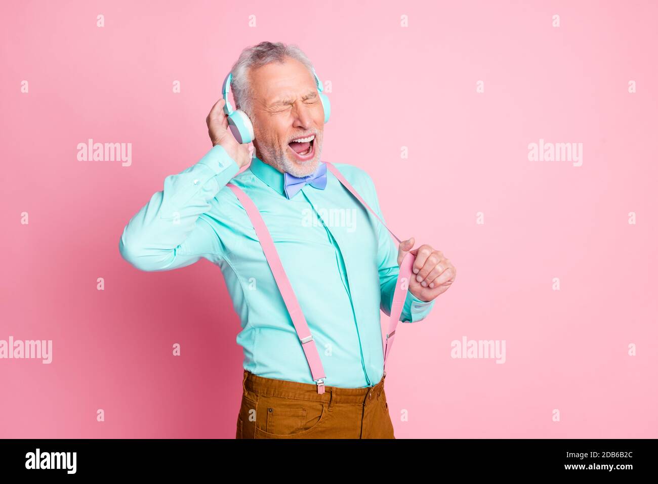 Portrait-Foto von Großvater trägt Kopfhörer hören Musik isoliert Auf rosa Hintergrund Stockfoto