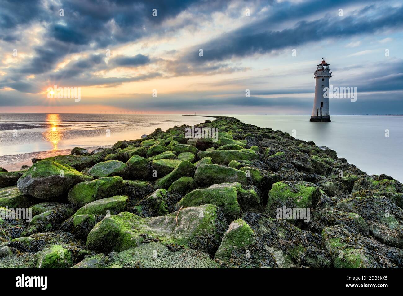 Dramatischer Abend mit Sonnenuntergang hinter Wolken am New Brighton Lighthouse in Merseyside, Großbritannien. Stockfoto