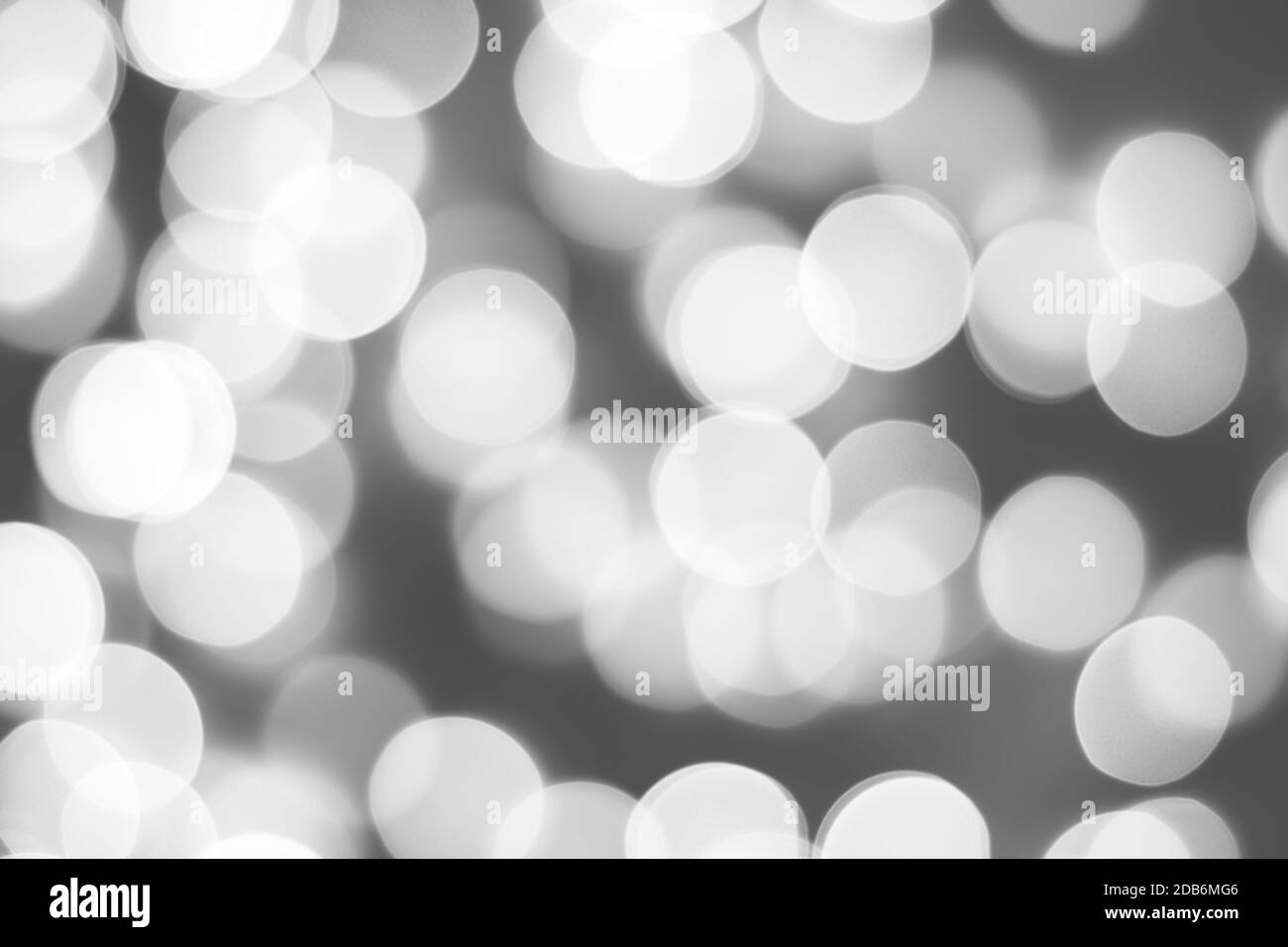 Schwarz-weiß verschwommenes Bild von weihnachtslichtern, monochromatischer abstrakter Hintergrund. Stockfoto