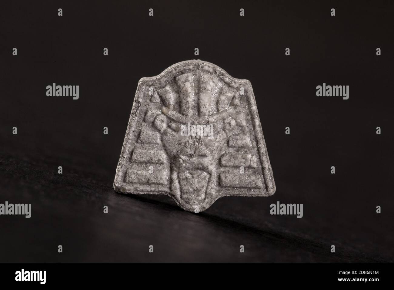 Pharao Ecstasy-Pille auf schwarzem Hintergrund. MDMA-unterstützte Psychotherapie. Stockfoto