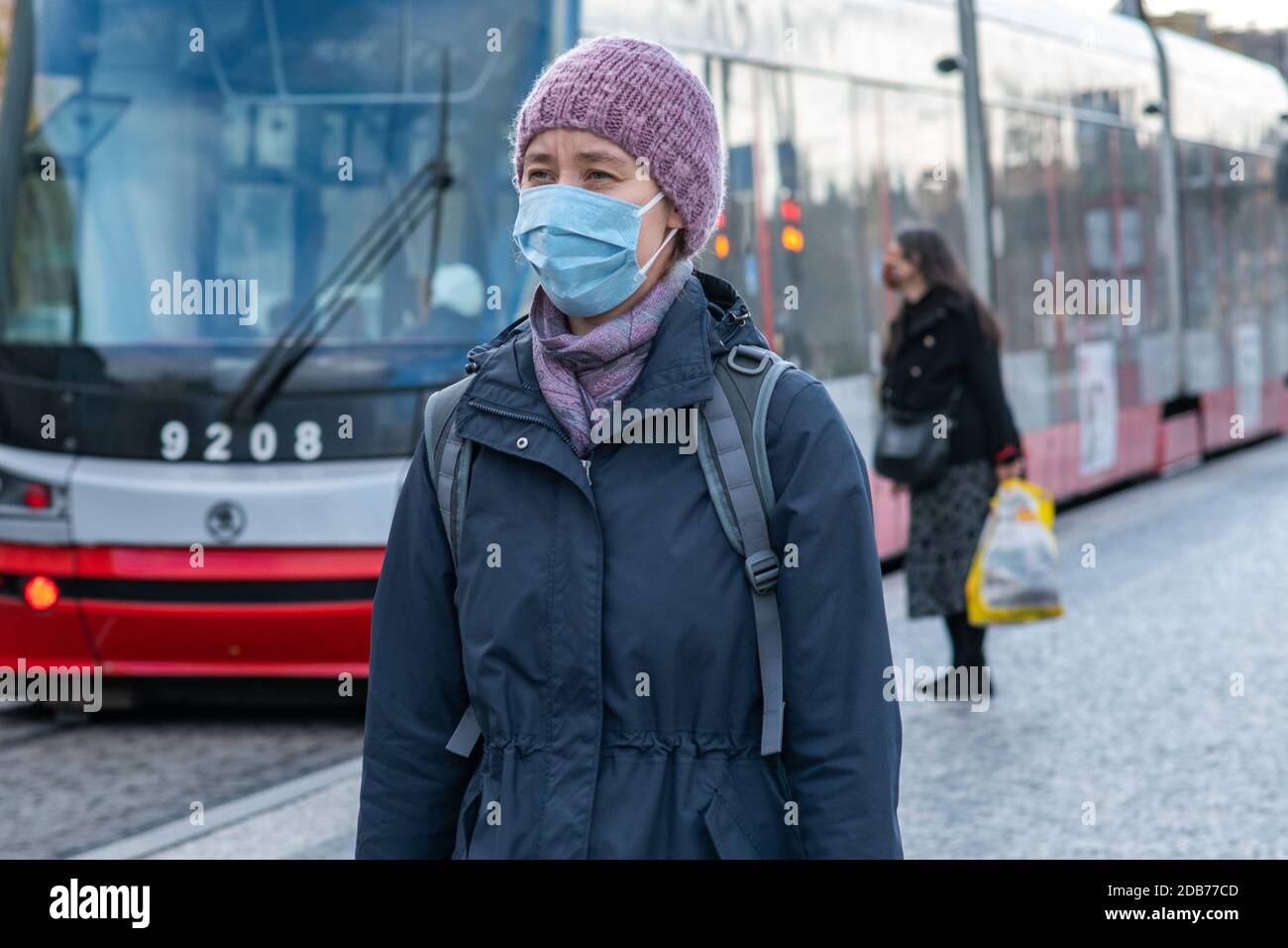 16.2020. Prag. Tschechische Republik. Eine Frau mit Maske an der Straßenbahnhaltestelle Hradcanska während der Quarantäne. Dies ist eine Sperrzeit in der Tschechischen Republik d Stockfoto