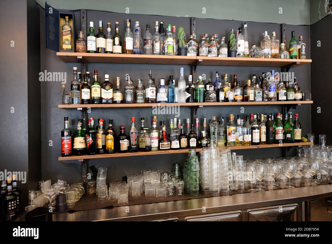 Große Auswahl an alkoholischen Getränken in Flaschen auf Regalen ausgestellt In einem Café oder einer Bar Stockfoto