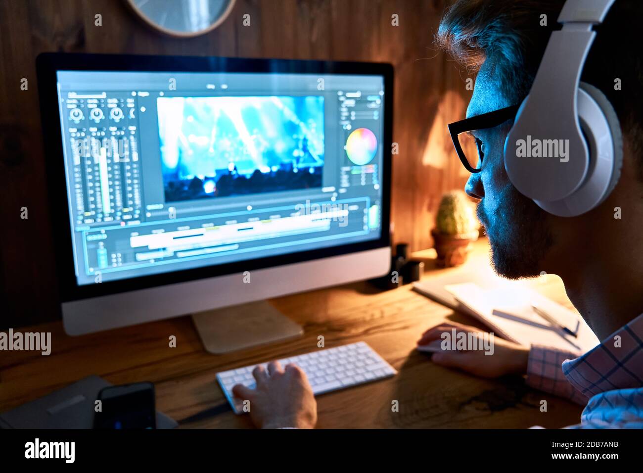Video-Editor für männliche Videofilmer mit pc-Computer, der im Heimbüro Filmmaterial bearbeitet. Stockfoto