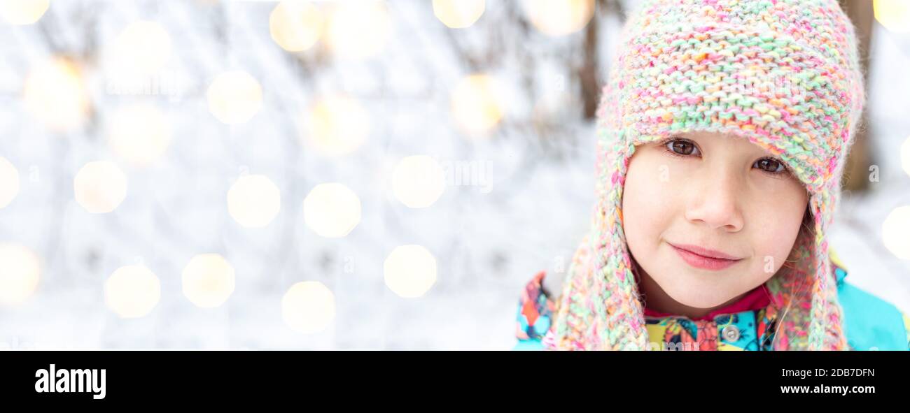 Nahaufnahme Porträt eines schönen kaukasischen Mädchen 6-7 Jahre in einem Winter gestrickt Hut mit Ohrenklappen, Blick auf die Kamera. Weihnachten und Neujahr. Stockfoto
