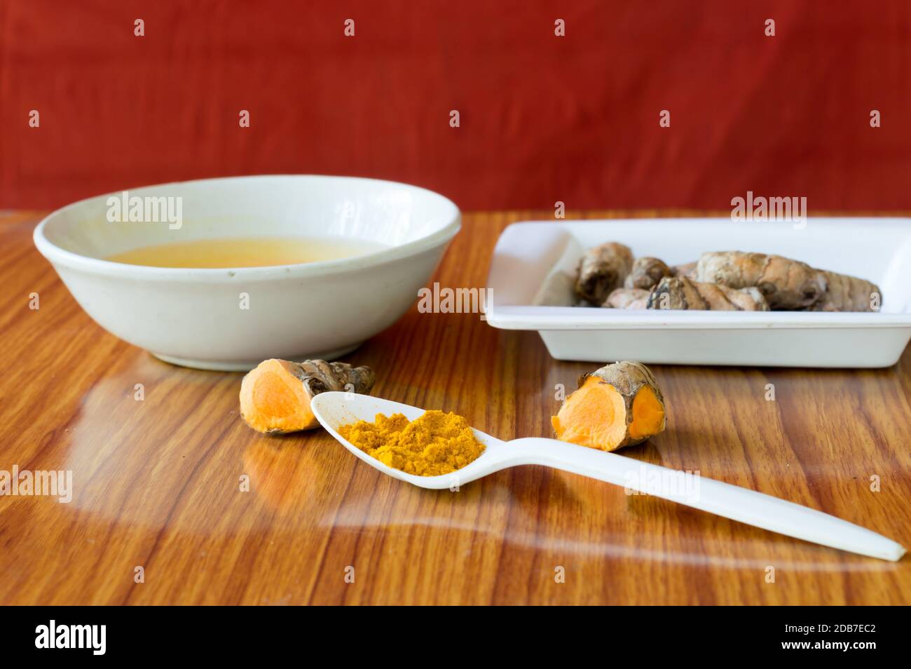Tischlöffel aus reinem turmerischem Haldi-Pulver. Haldi-turmmilchrezept. Coronavirus anti-virale entzündliche Lebensmittel und Getränke Hintergrund. Gesundheitsfürsorge nür Stockfoto
