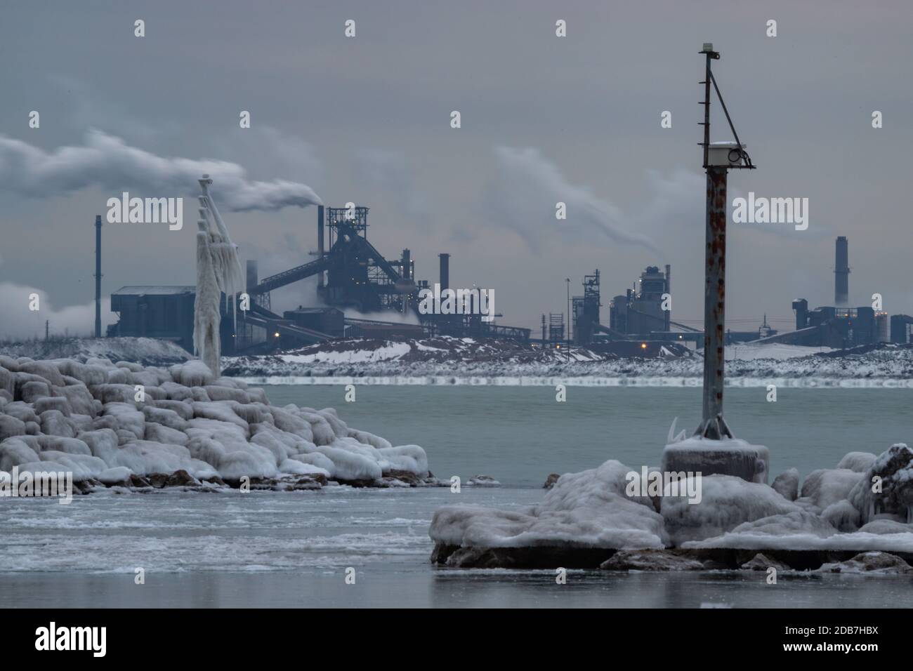 Die Küste von ICY Lake Michigan in Whiting, Indiana, mit der Stahlfabrik ArcelorMittal im nahe gelegenen East Chicago, Indiana. Stockfoto