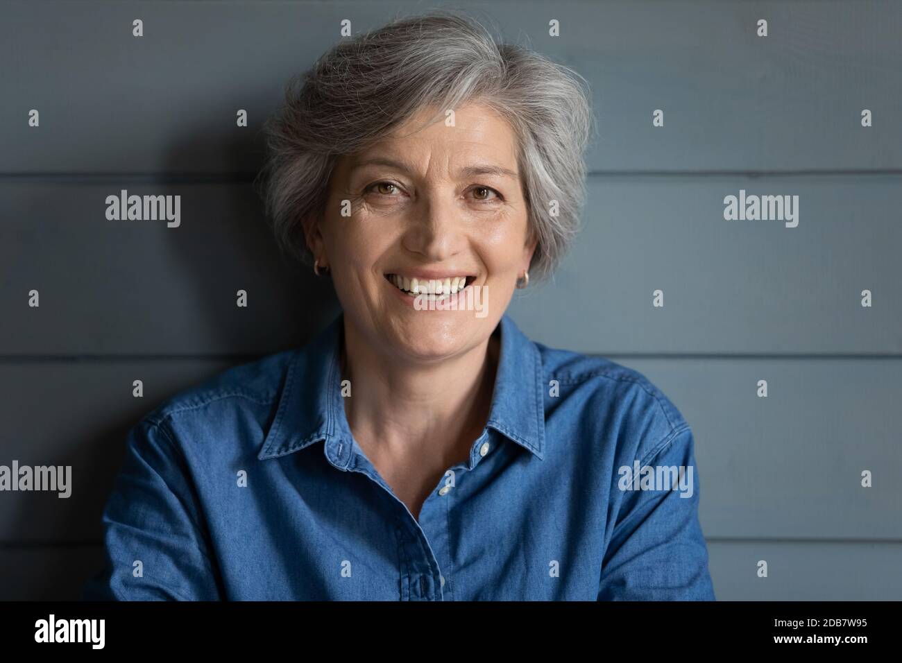 Kopfaufnahme Porträt lächelnd grauhaarige Frau Blick auf die Kamera Stockfoto