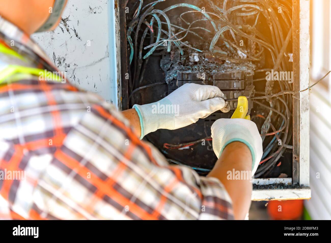 Elektriker, der eine Schalttafel nach einem Elektrobrand repariert, Thailand Stockfoto