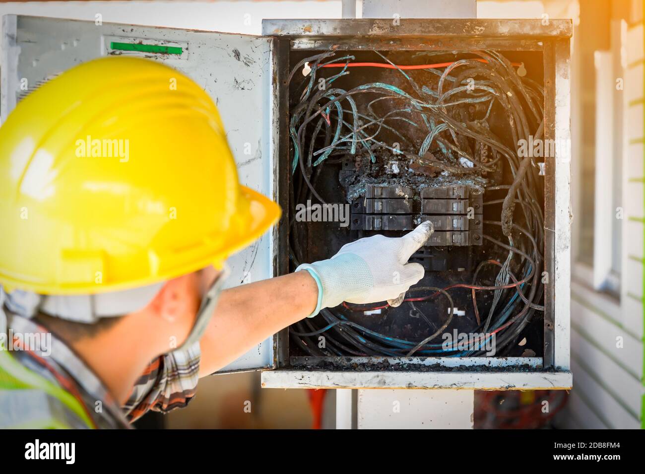 Elektriker, der eine Zentrale nach einem Elektrobrand überprüft, Thailand Stockfoto