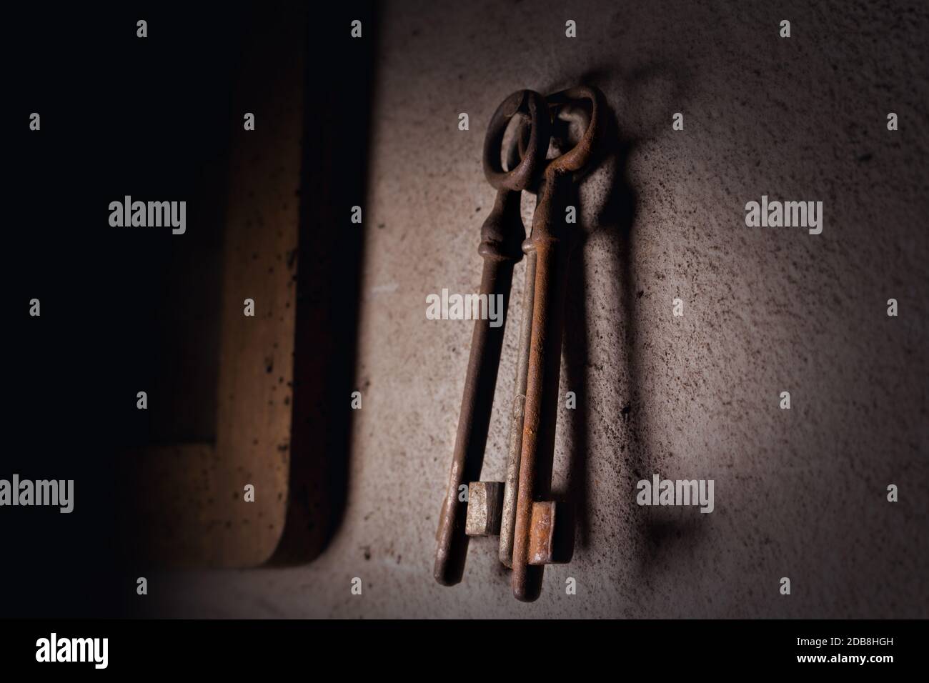 Alte verrostete Schlüssel hängen an der Wand Stockfoto