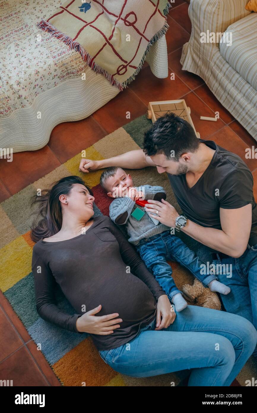 Eltern spielen mit ihrem traurigen kleinen Sohn im Leben Zimmer Stockfoto