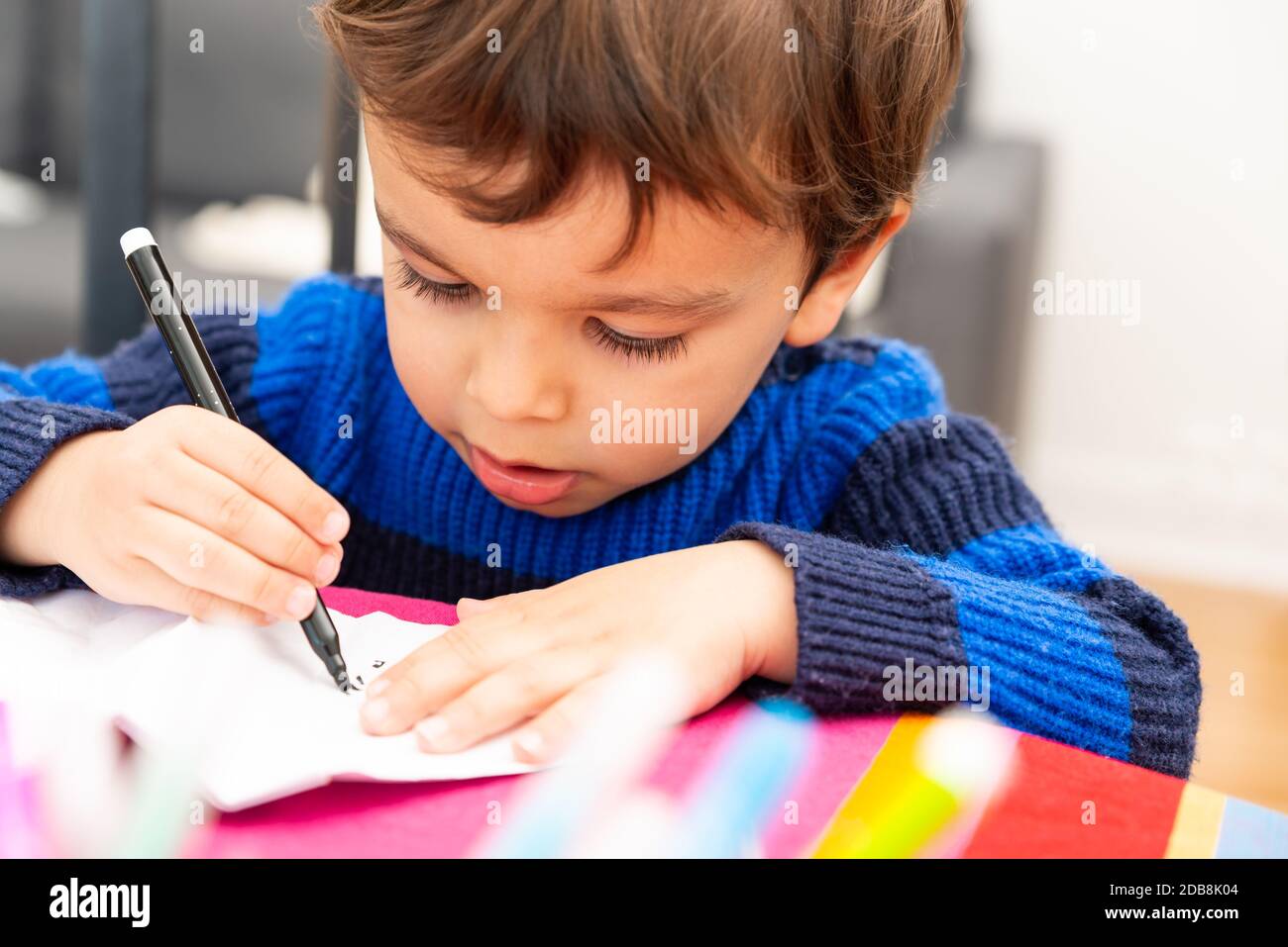 Kleinkind Zeichnung zu Hause mit einem schwarzen Filzstift Stockfoto