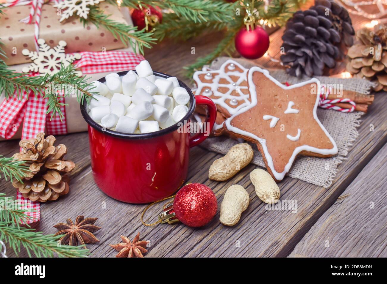 Weihnachtliche Holzuntermalung mit einem Becher heißen Getränks und einem Tannenzweig. Frohe Weihnachten und Neujahr. Stockfoto