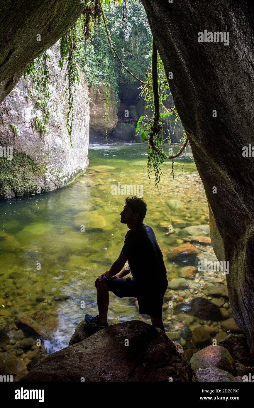 Mann sitzt in Höhle im Regenwald, Serra Dos Orgaos Nationalpark, Rio de Janeiro Staat, Brasilien Stockfoto