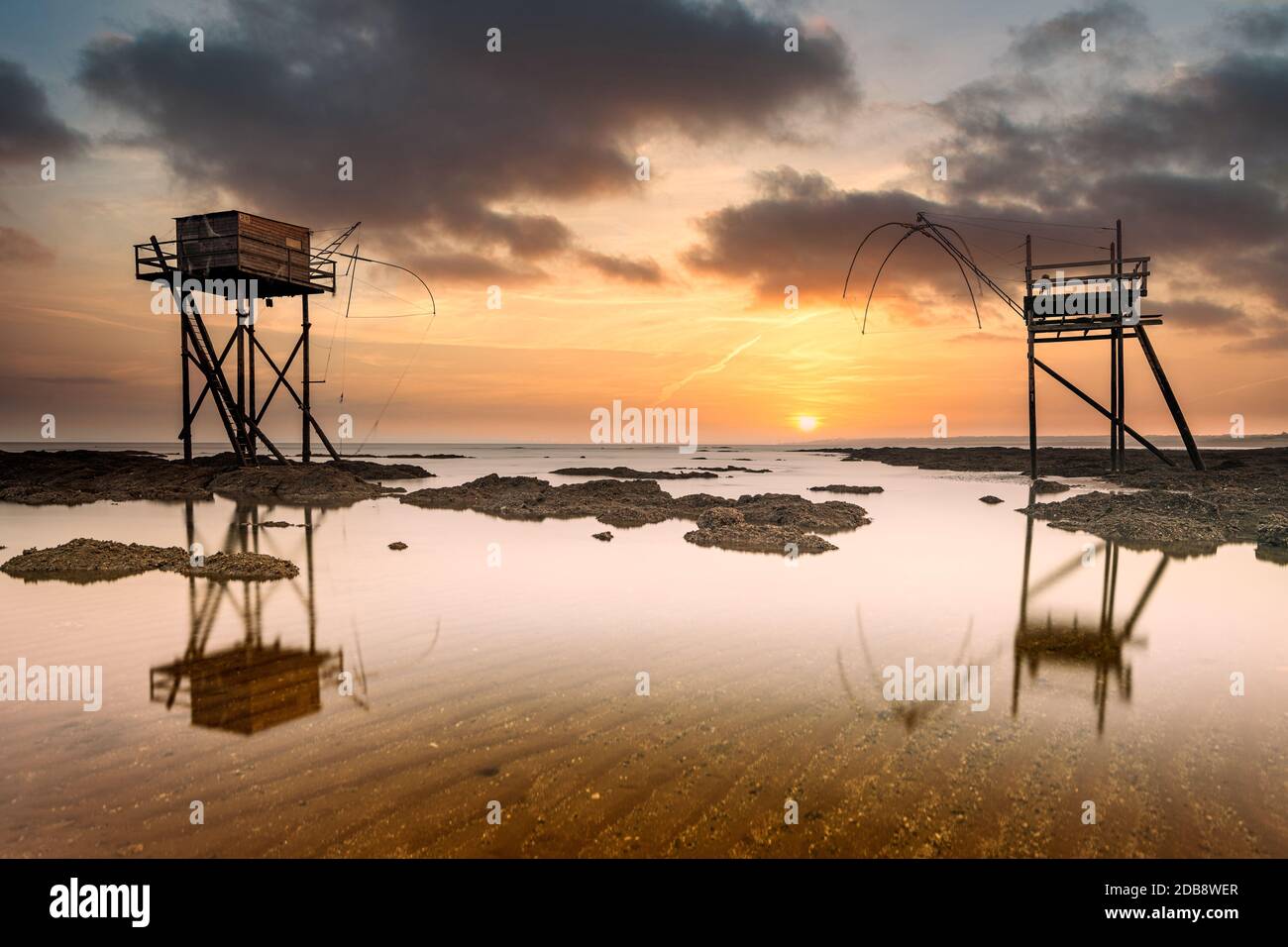 Fischerhütten am Strand bei Ebbe bei Sonnenuntergang, Saint-Michel-Chef-Chef, Loire-Atlantique, Frankreich Stockfoto