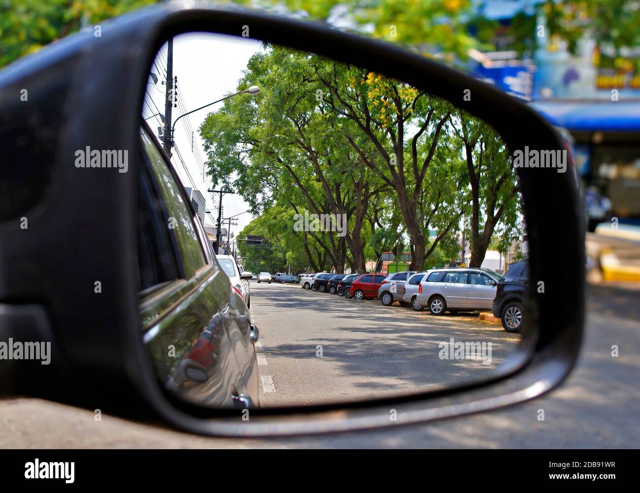 Blick auf viele Autos geparkt durch den Rückspiegel in einer kleinen Stadt in Brasilien. Stockfoto