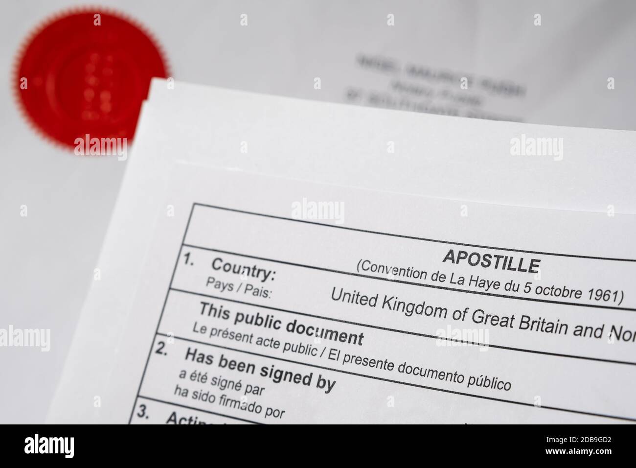 UK Apostille Urkunde Ecke und roten Notar öffentlichen Stempel auf offiziellem Dokument auf dem verschwommenen Hintergrund gesehen. Stockfoto
