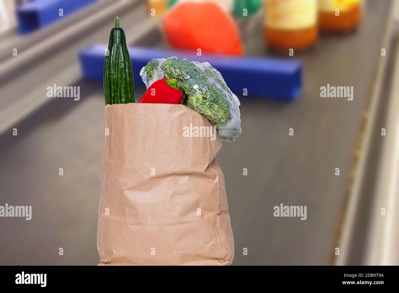 Nahaufnahme auf einer braunen Papier-Einkaufstasche mit frischem Gemüse auf dem Kassenförderband bei Supermarket. Konzept der Stärkung des Immunsystems A Stockfoto