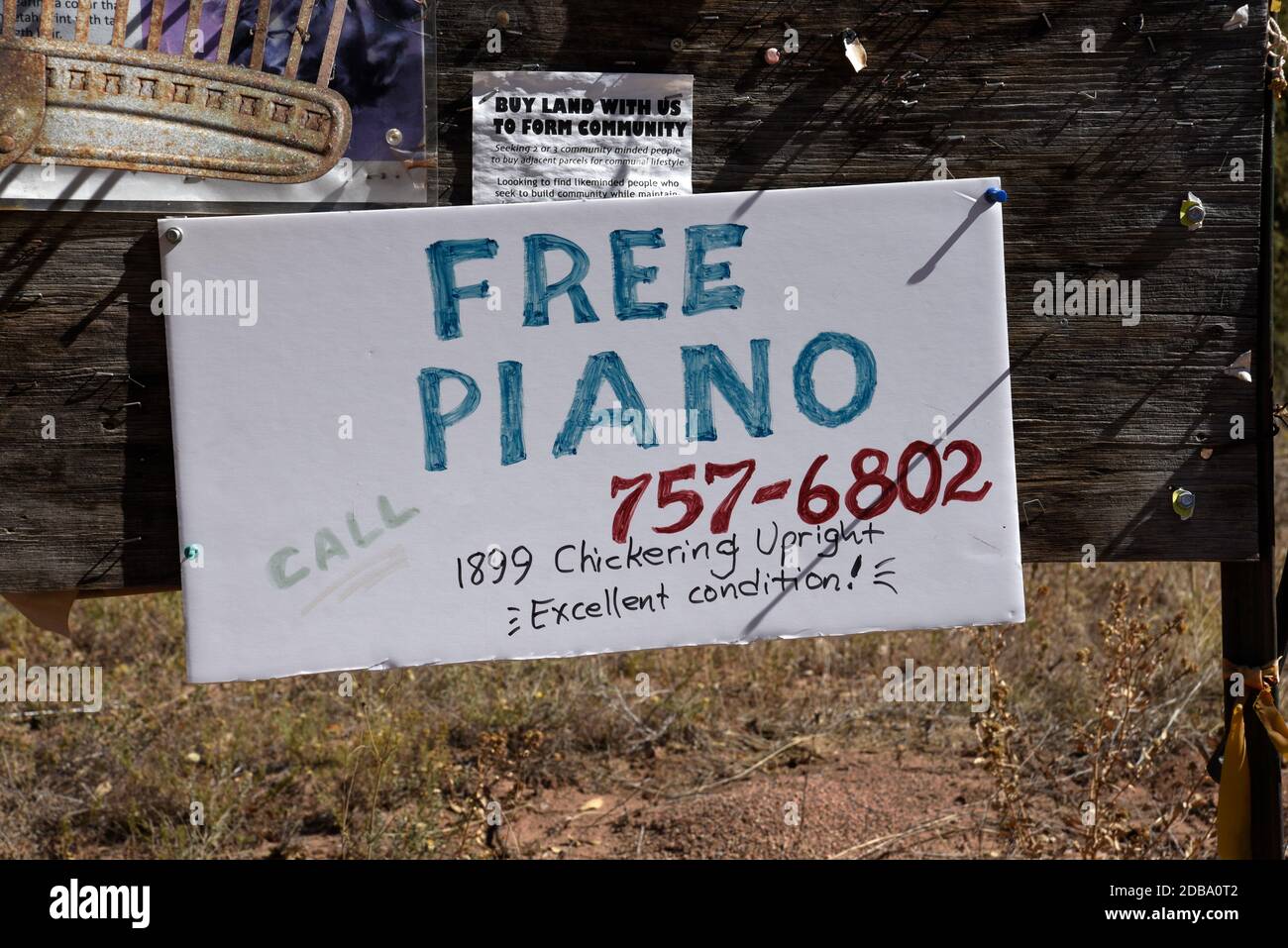 Ein Schild an einer rustikalen Community Pinnwand neben einer Straße in Pecos, New Mexico, bietet ein freies Klavier zu einem guten Zuhause. Stockfoto