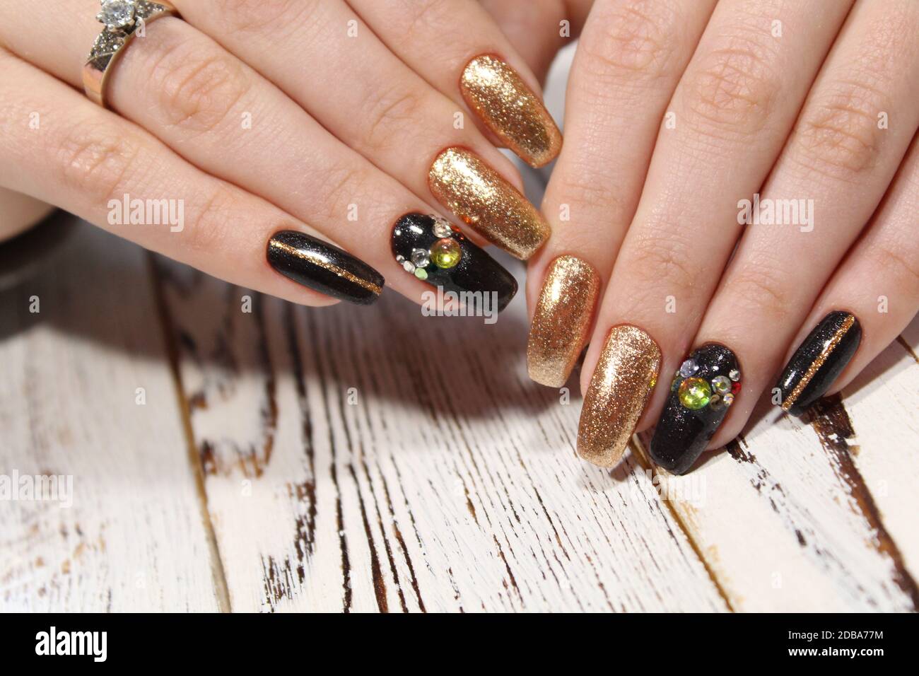 Mode Maniküre auf lange Nägel von Gold und Schwarz Stockfotografie - Alamy