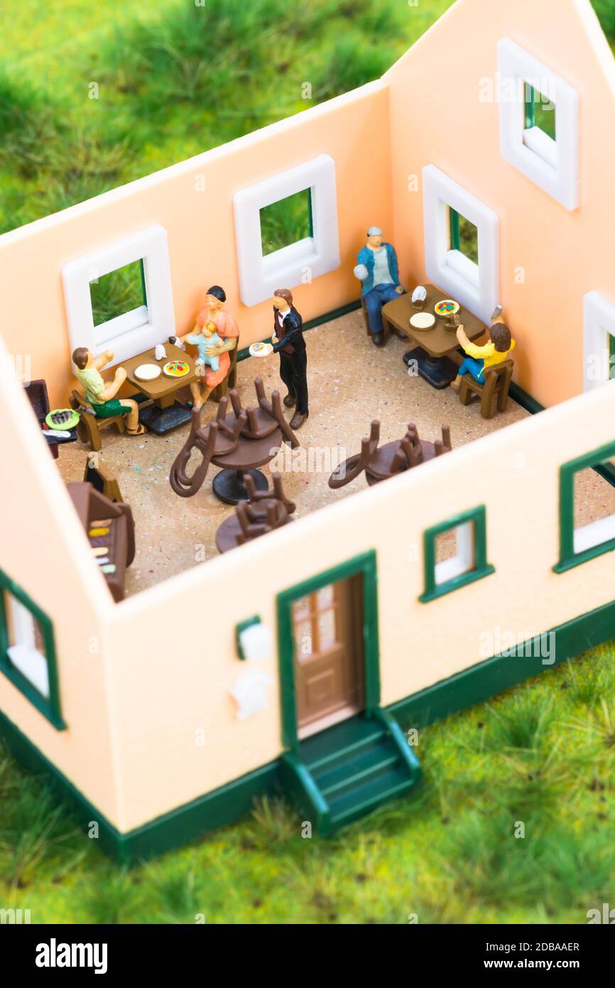 Konzept der sozialen Distanzierungsregeln mit Miniaturmenschen in einem Restaurant Stockfoto