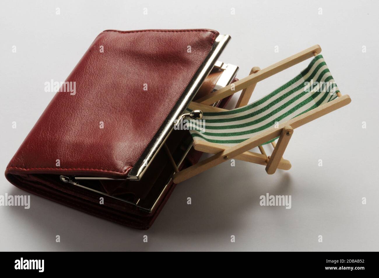 Liegestuhl mit Geldbörse auf weißem Hintergrund Stockfoto