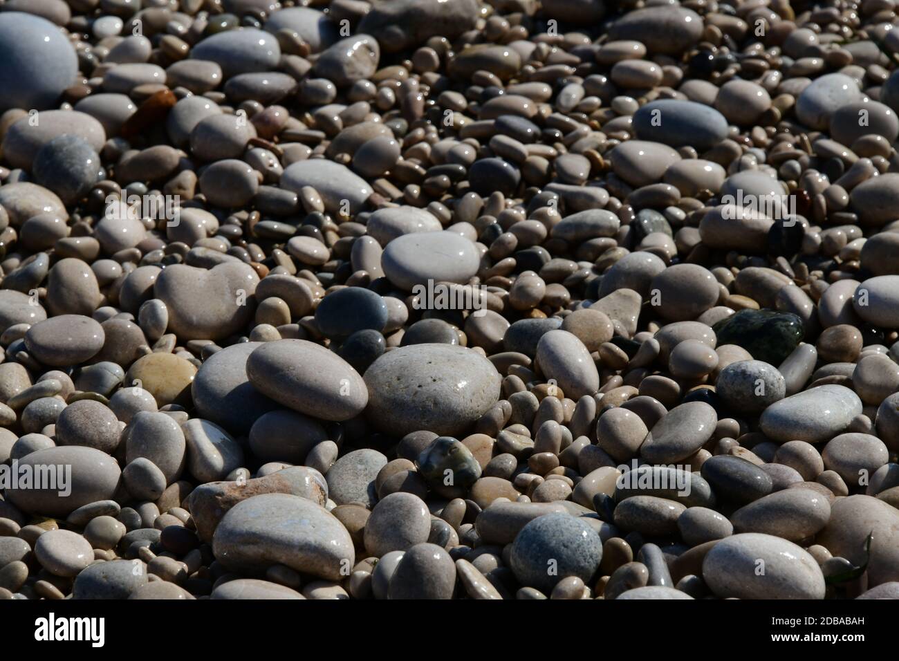 Große, kleine, runde Steine am Mittelmeer in der Provinz Alicante, Spanien Stockfoto
