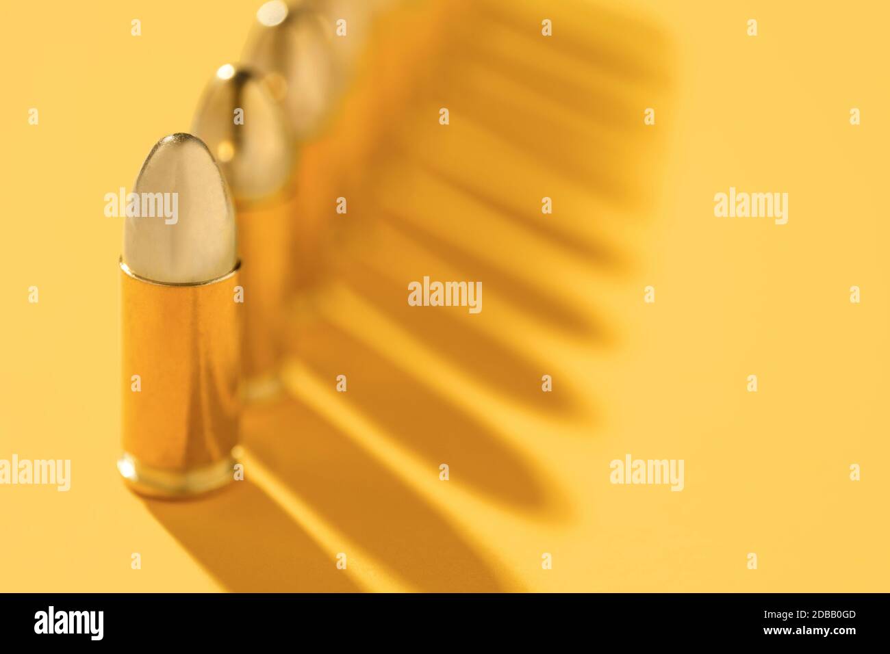 Reihe von goldenen Kugeln auf gelbem Hintergrund Stockfoto