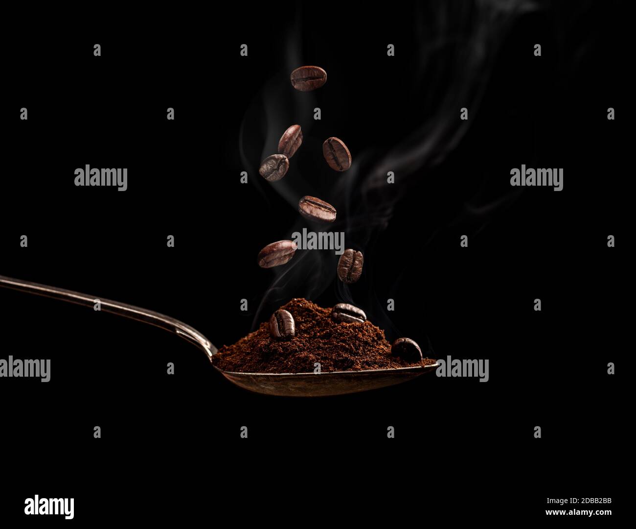 Dampfgaren geröstete Kaffeebohnen in einem Löffel auf einem schwarzen Hintergrund Stockfoto