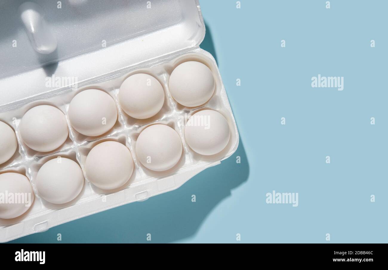 Eier im Karton auf blauem Hintergrund Stockfoto