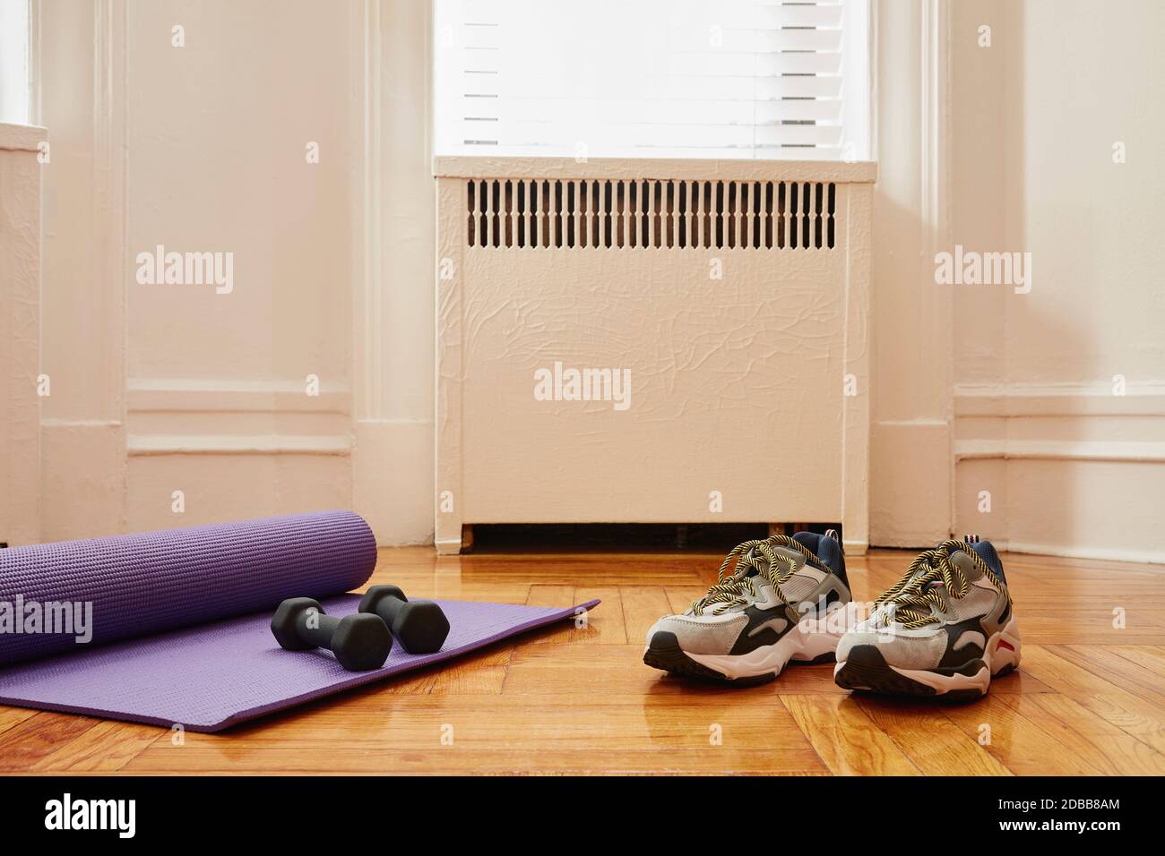 Yogamatte, Gewichte und Sportschuhe auf dem Boden im Fitnessstudio zu Hause Stockfoto