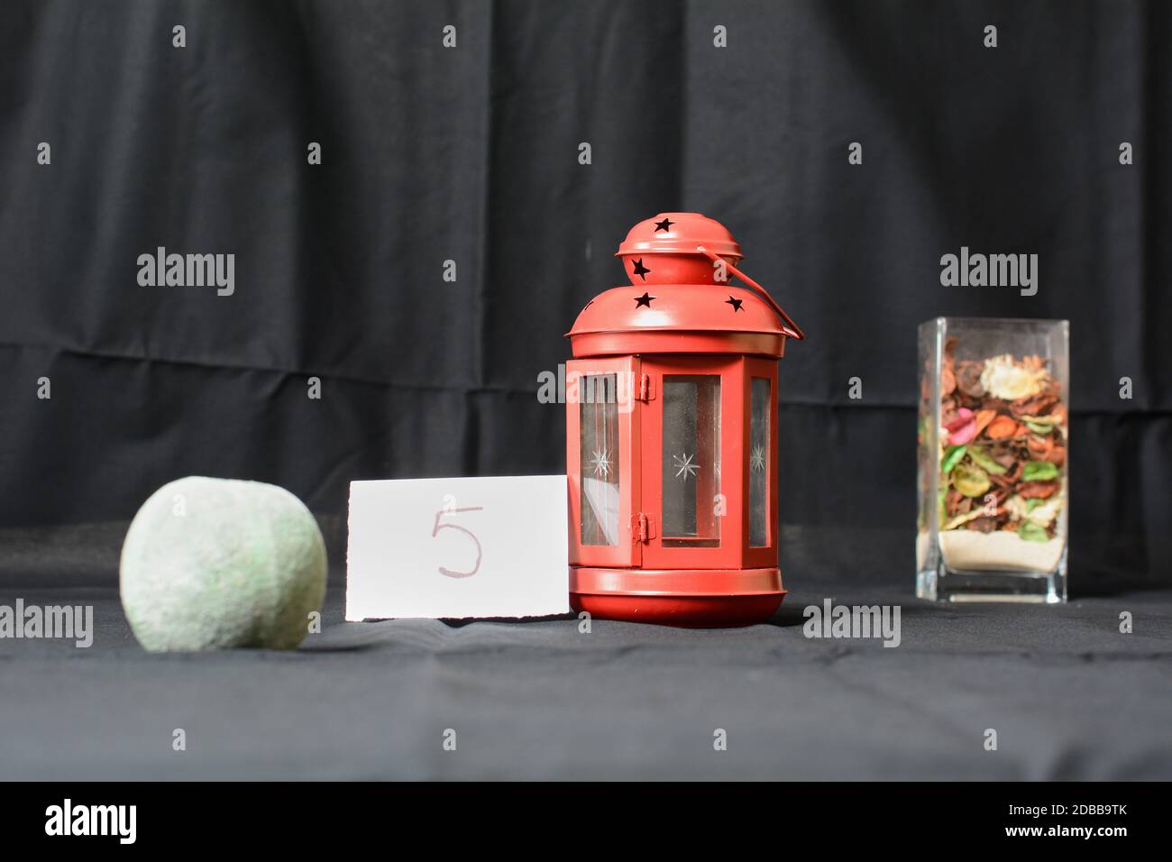 Rote Laterne mit Schale mit Sand. Fotografische Öffnung Übung Blende Stockfoto