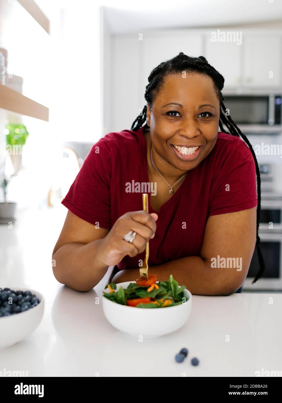 Portrait der lächelnden Frau mit gesunden Salat in der Küche Stockfoto