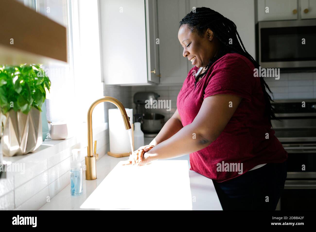 Frau Waschen der Hände in der Küche Stockfoto