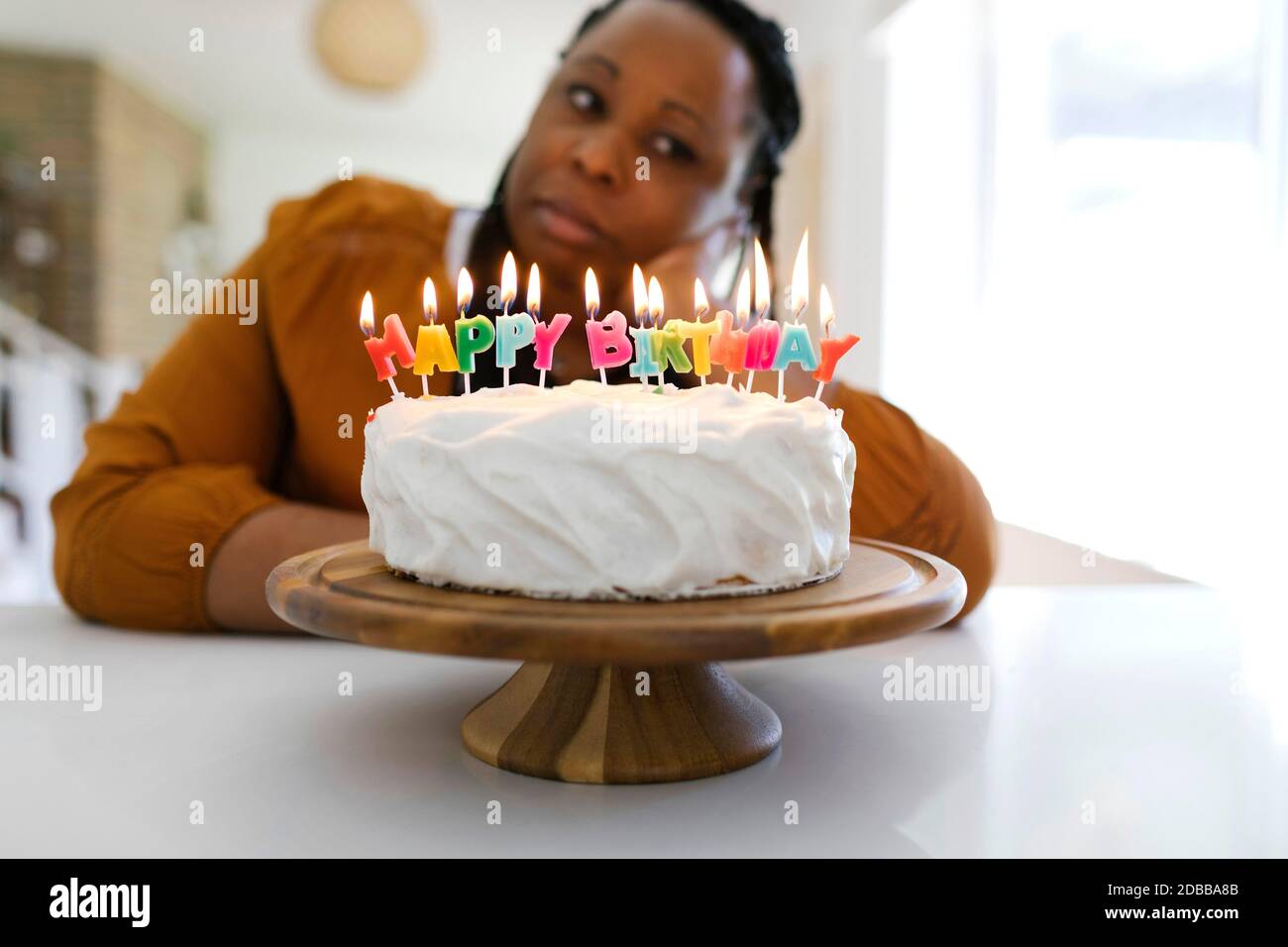 Porträt der Frau hinter Geburtstagskuchen Stockfoto