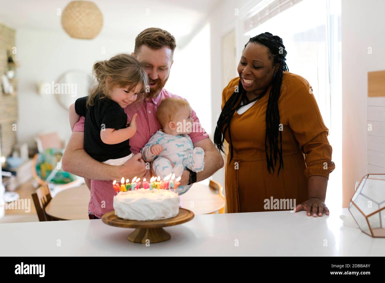 Frau und Mann mit Kindern (2-3, 9-11 Monate) feiern Geburtstag zu Hause Stockfoto