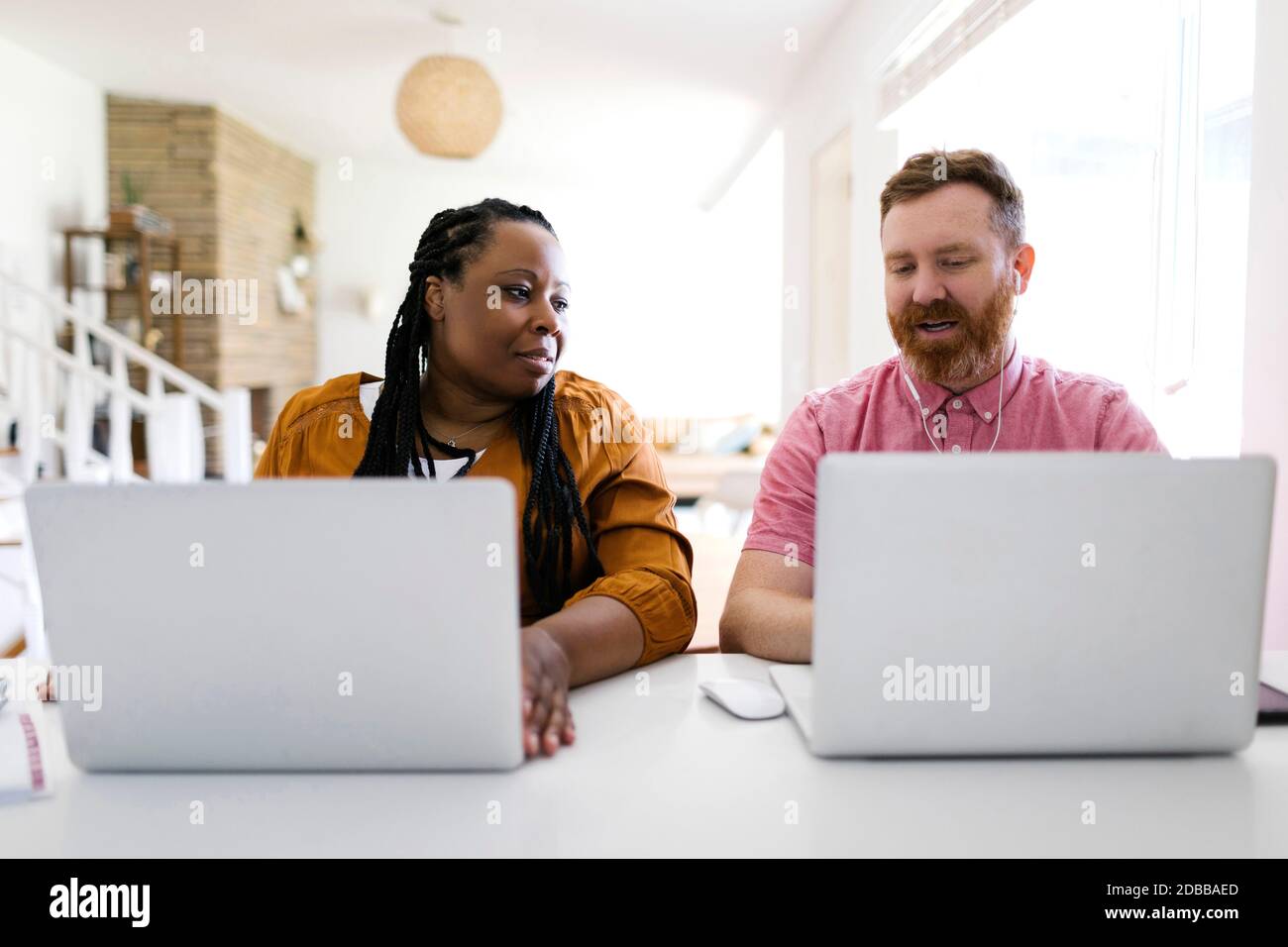 Mann und Frau, die im Home Office mit Laptops arbeiten Stockfoto