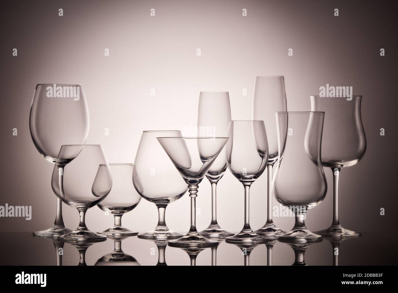 Set Gläser für verschiedene alkoholische Getränke und Cocktails auf dunkelgrauem Hintergrund. Leeren Sie klare Gläser. Stockfoto