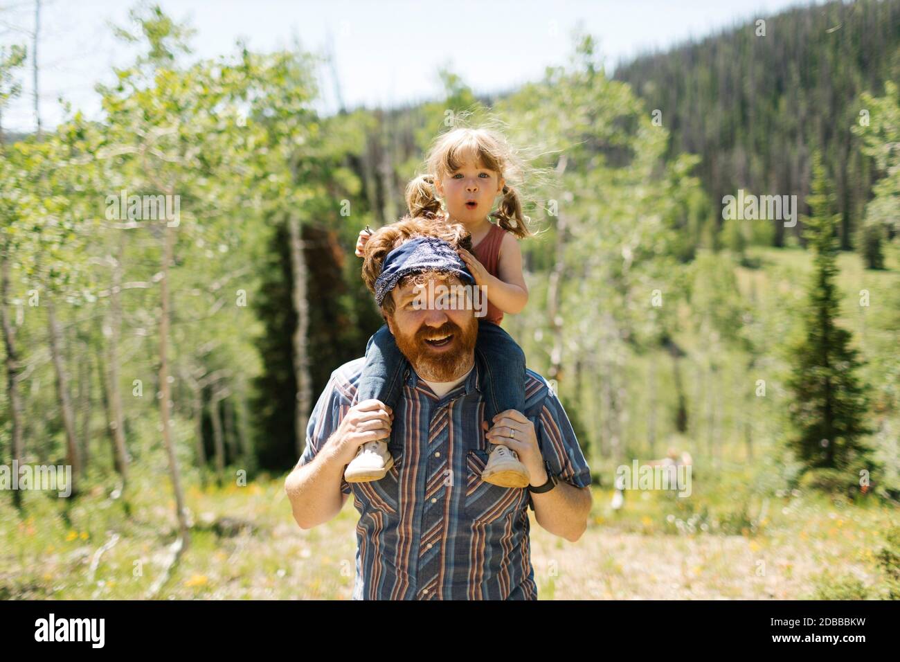 USA, Utah, Uinta National Park, Porträt eines lächelnden Mannes, der seine Tochter (2-3) auf den Schultern in der Landschaft trägt Stockfoto