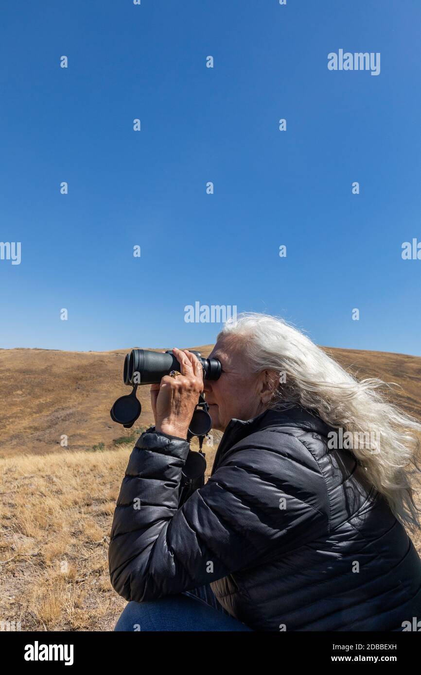 USA, Idaho, Bellevue, ältere Frau schaut durch Ferngläser in der Wüste Stockfoto