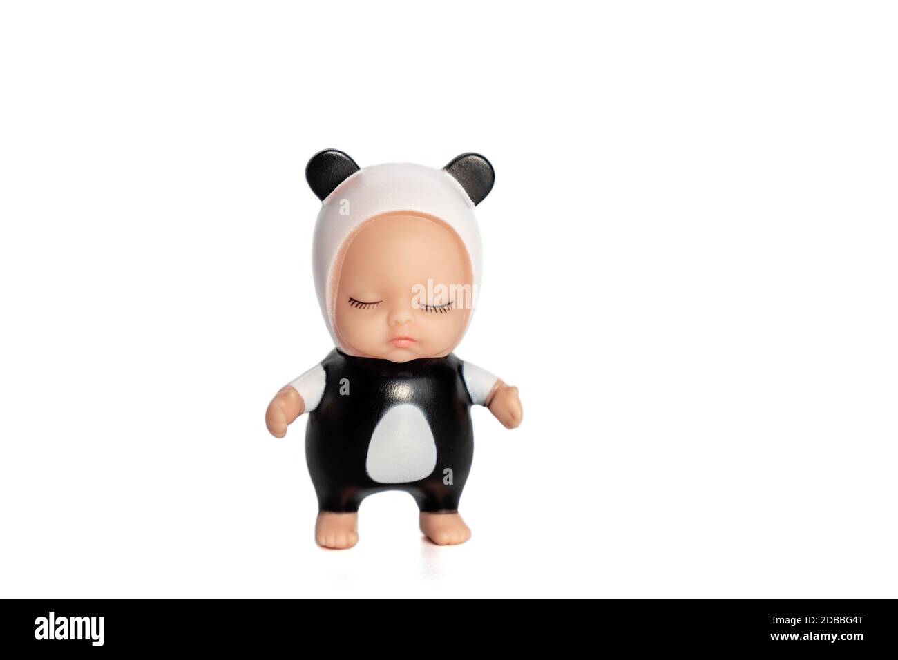 Niedliche kleine Puppe im Panda Kostüm mit geschlossenen Augen. Steht auf einem weißen isolierten Hintergrund. Ein entzückendes Spielzeug für ein Geschenk oder ein Kinderspiel. Weichfokus. Stockfoto
