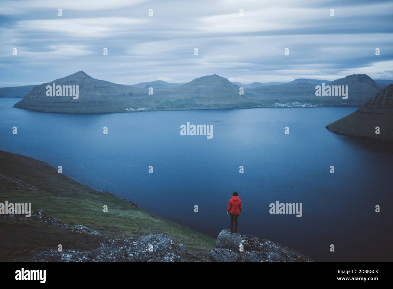 Dänemark, Färöer, Klaksvik, Frau auf Felsen stehend und auf den Fjord schauend Stockfoto