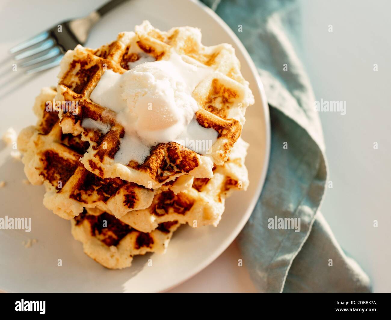 Ricotta-Käse-Chaffles für Keto-Diät. Stapel von belgischen Waffeln mit Ricotta und Zitrone, dekoriert mit Eislöffel. Platz für Text kopieren. Natürlicher Sonnenuntergang Stockfoto