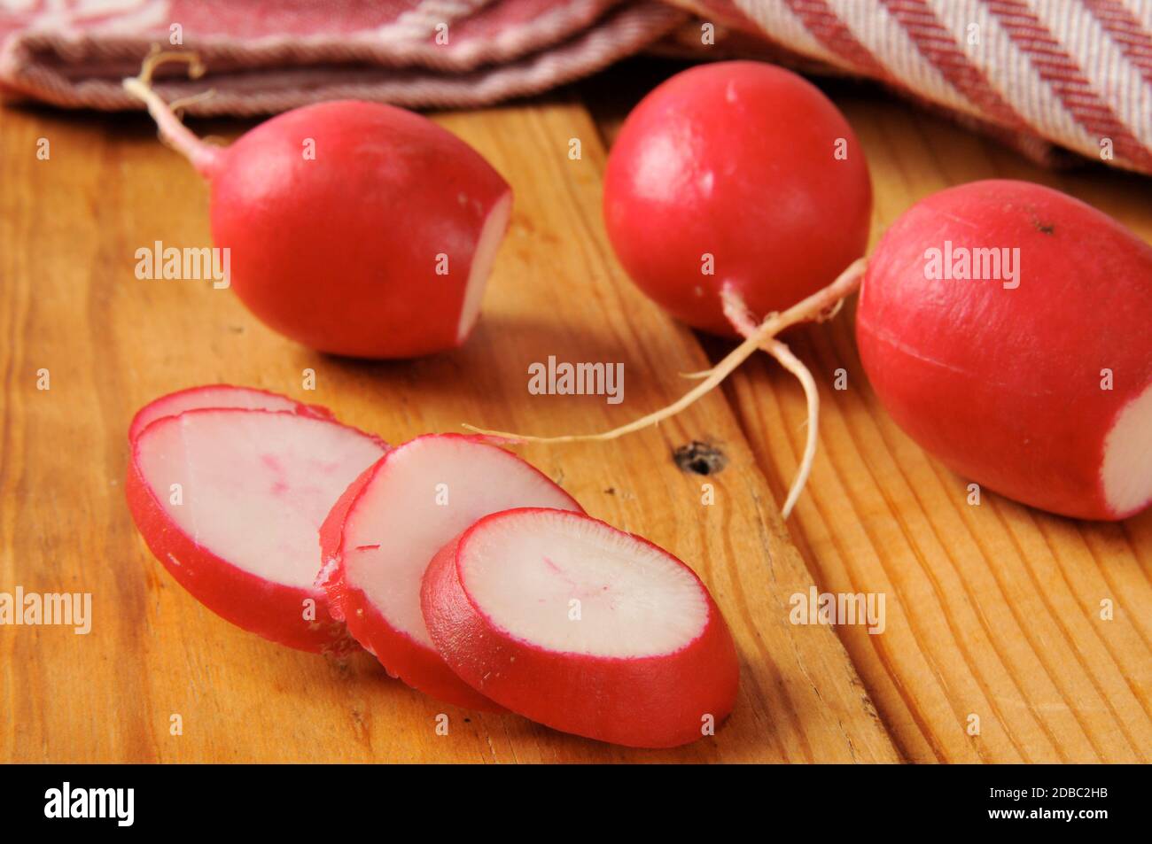 Radieschen in Scheiben auf einer rustikalen Holztheke Stockfoto