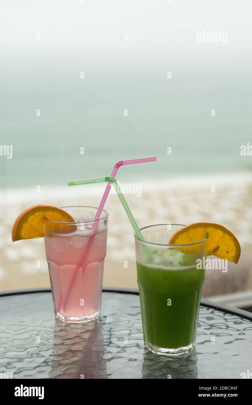 Bunte Cocktails vom Balkon mit Blick auf den Strand Stockfoto